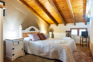 a bedroom with a bed with a wooden ceiling at Casa La Charca in Amavida