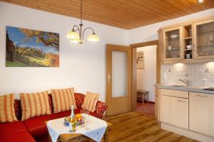 a living room with a red couch and a table at Ferienwohnung Zugspitze in Grainau