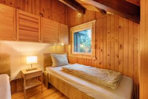 a bedroom with a bed in a wooden wall at Dänisches Tiny Haus Brekendorf in Brekendorf