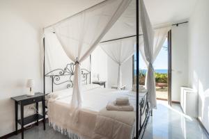 a bedroom with a canopy bed with a view of the ocean at Cala D'Aspide in Santa Caterina di Nardò