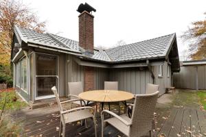 a patio with a table and chairs on a deck at Dänisches Tiny Haus Brekendorf in Brekendorf