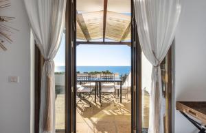 a room with a view of the ocean through glass doors at Cala D'Aspide in Santa Caterina di Nardò