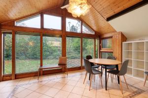 a dining room with a table and chairs and windows at Dänisches Tiny Haus Brekendorf in Brekendorf