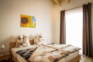 a bedroom with a bed and a large window at Ferienwohnung Lindenhof in Dormettingen