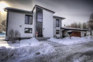 a white house with snow around it at Ferienwohnung Lindenhof in Dormettingen