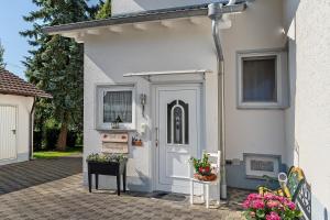 a white house with a white door and some flowers at Ferienwohnung Viola in Schwanau in Schwanau