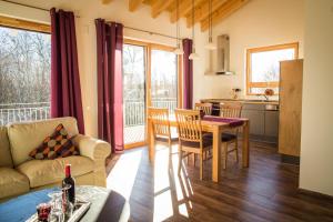 a kitchen and living room with a table and a couch at Ferienwohnung Lindenhof in Dormettingen +5 photos