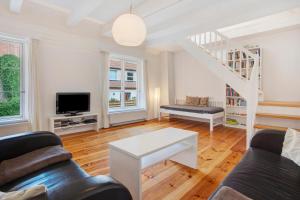 a living room with a couch and a tv at Alte Seifensiederei 2 in Stralsund