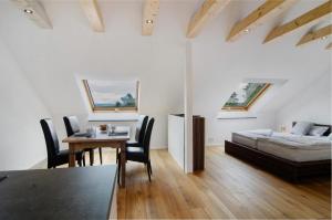 a living room with a table and a bed at Aussichtsreich Am See in Uhldingen-Mühlhofen