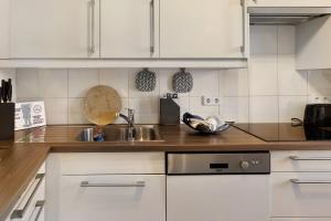 a kitchen with white cabinets and a sink at Ferienwohnung Havelvorland in Havelberg