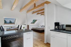 a kitchen with white cabinets and a living room at Aussichtsreich Am See in Uhldingen-Mühlhofen