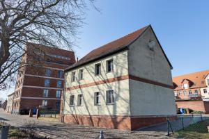 a white building with a red stripe on the side of it at Ferienwohnung Havelvorland in Havelberg