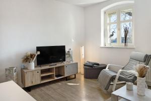 a living room with a flat screen tv on a cabinet at Ferienwohnung Havelvorland in Havelberg