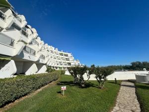 a large white building with a walkway in front of it at Plage du Couchant in La Grande Motte