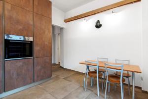 a kitchen with a table and chairs and a refrigerator at La Sartoria in Porlezza