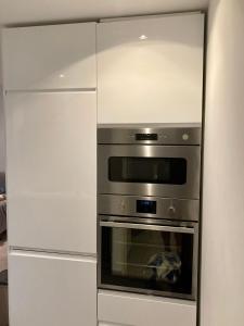a stainless steel oven in a kitchen with white cabinets at Plage du Couchant in La Grande Motte