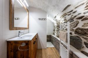 a bathroom with a sink and a stone wall at Appartement ô Canton in Val Cenis +25 photos