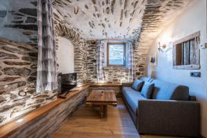 a living room with a blue couch and a table at Appartement ô Canton in Val Cenis