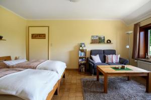 a living room with a bed and a couch at Ferienwohnung am Eiderdeich in Delve