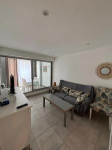 a living room with a couch and a table at Plage du Couchant in La Grande Motte