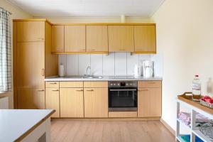 a kitchen with wooden cabinets and a stove top oven at Ferienwohnung am Eiderdeich in Delve