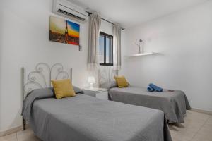 a bedroom with two beds and a window at Hostal Avenida in Conil de la Frontera