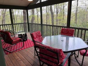 a screened in porch with a table and chairs at Chestnut Ridge in Connestee · Chestnut Ridge in Connestee Falls in Rosman +15 photos