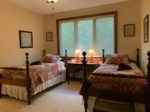 a bedroom with two beds and a desk and a window at Pine Hill · Pine Hill in Sherwood Forest in Rosman