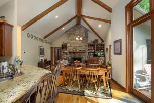 a kitchen and dining room with a table and a fireplace at Pine Hill · Pine Hill in Sherwood Forest in Rosman