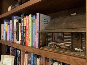 a book shelf filled with books and a bird house at Pine Hill · Pine Hill in Sherwood Forest in Rosman