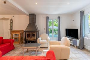 a living room with a red couch and a fireplace at Plein coeur du Luberon in Apt