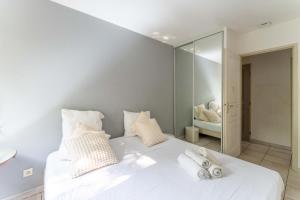 a bedroom with a white bed with towels on it at Plein coeur du Luberon in Apt +22 photos