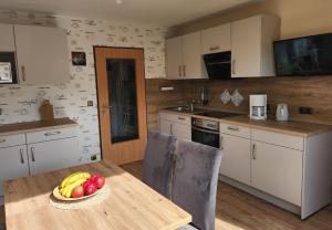 a kitchen with a table with a bowl of fruit on it at Gästehaus Nietmann_ Ferienwohnung 7 in Altenau