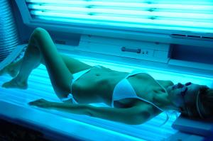 a woman laying in a bed with a blue light at Gästehaus Nietmann_ Ferienwohnung 7 in Altenau +15 photos