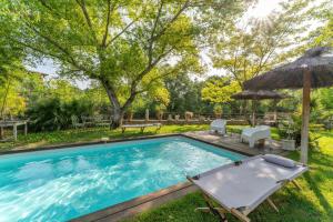 a swimming pool with an umbrella and a table and chairs at Plein coeur du Luberon in Apt