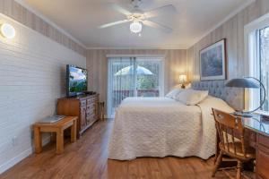 a bedroom with a bed and a television and a table at Bike Path Getaway in Town · On bike path, NEW KITCHEN,walk to St in Brevard