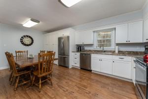 a kitchen with white cabinets and a table and chairs at Bike Path Getaway in Town · On bike path, NEW KITCHEN,walk to St in Brevard