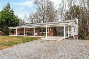 a brick house with a porch and a driveway at Bike Path Getaway in Town · On bike path, NEW KITCHEN,walk to St in Brevard