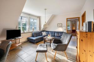 a living room with a couch and a tv at Haus Deichgraf in Nordstrand