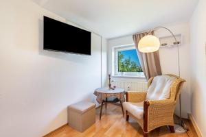 a room with a table and a chair and a tv at Yvette's Ferienwohnung in Lugau