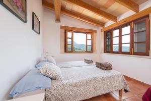 two beds in a room with windows at Dos Villas in Sóller +30 photos