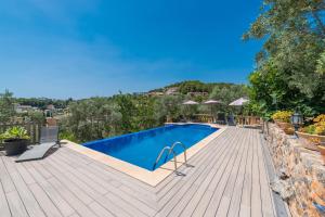 a swimming pool on top of a wooden deck at Dos Villas in Sóller