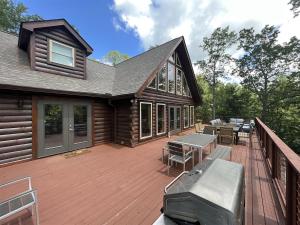 a wooden deck with tables and benches on a house at El Escorpio North · El Escorpio North - New Rental in Brevard