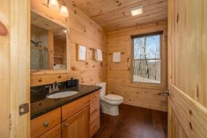 a log cabin bathroom with a sink and a toilet at El Escorpio North · El Escorpio North - New Rental in Brevard +18 photos