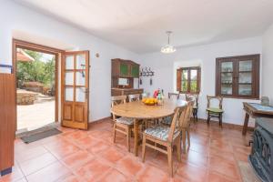 a kitchen and dining room with a wooden table and chairs at Dos Villas in Sóller