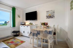 a dining room with a table and a tv at Bäckerhus - Ferienwohnung 6 in Wiek auf Rügen +17 photos