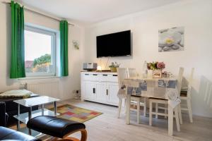 a living room with a dining room table and a tv at Bäckerhus - Ferienwohnung 6 in Wiek auf Rügen