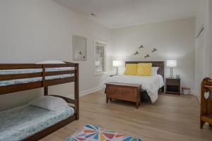 a bedroom with two bunk beds with yellow pillows at Hummingbird Hideaway · Hummingbird Hideaway in Connestee Falls in Brevard +26 photos