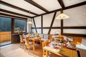 a dining room with wooden tables and chairs at Haus Am Kaltenbach in Enzklösterle