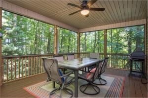 a screened in porch with a table and chairs at Hummingbird Hideaway · Hummingbird Hideaway in Connestee Falls in Brevard